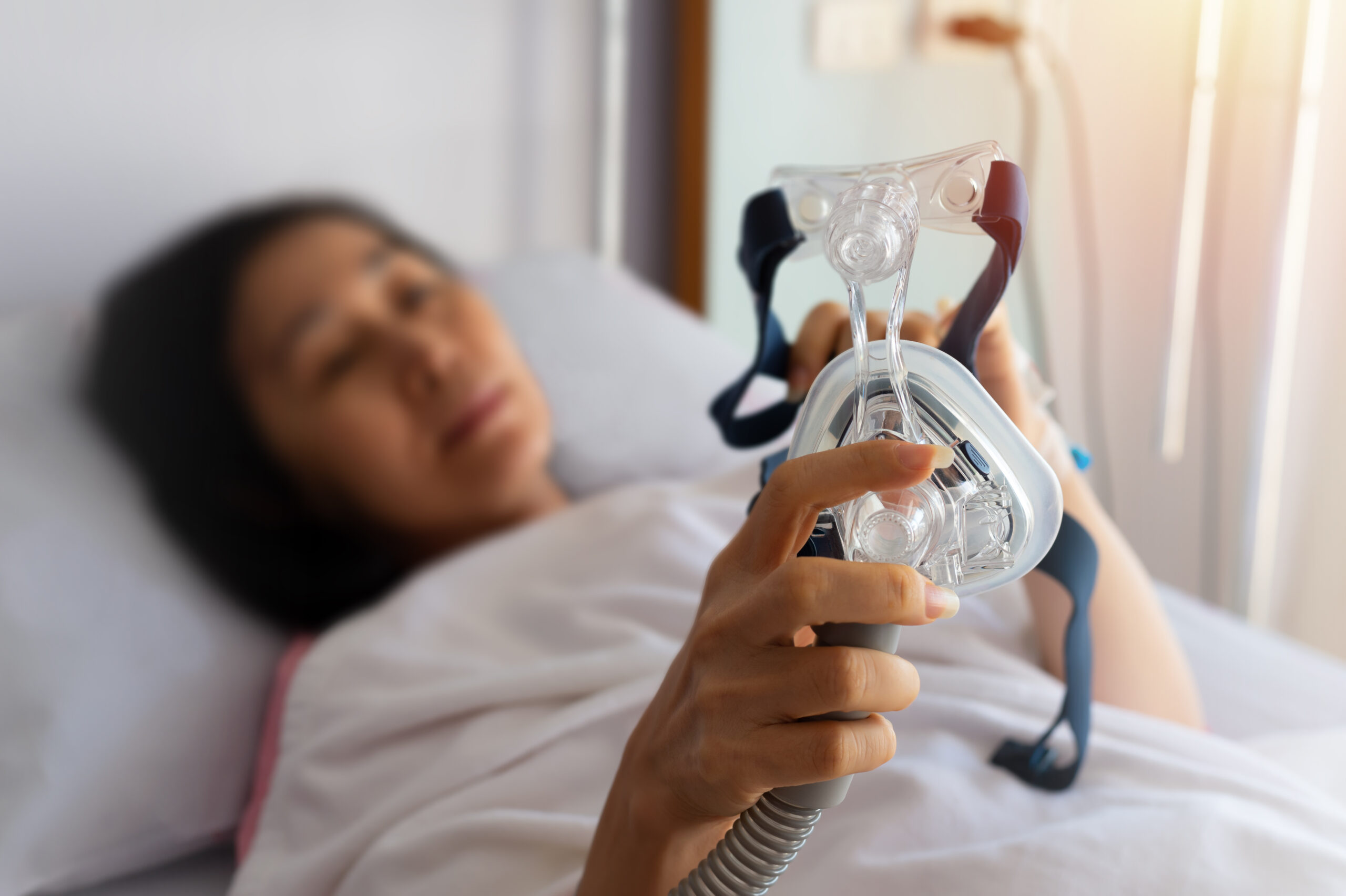 woman laying down with CPAP machine